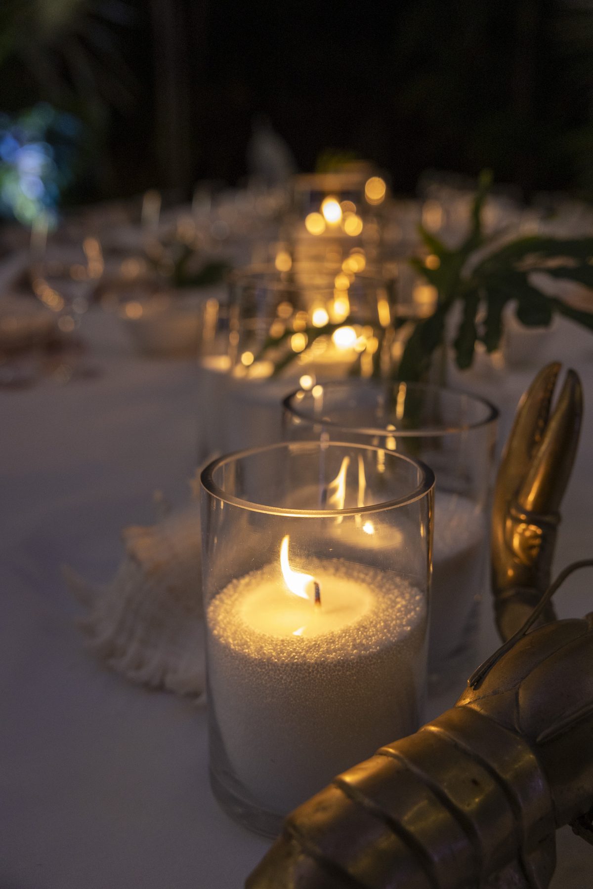 White sand wax candle glowing in glass